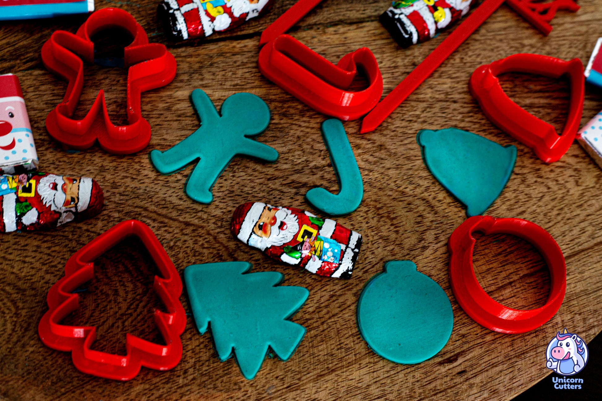 Set of mini Christmas cookie cutters, including a cake topper saying Merry Christmas. The scene is decorated with mini Christmas chocolates